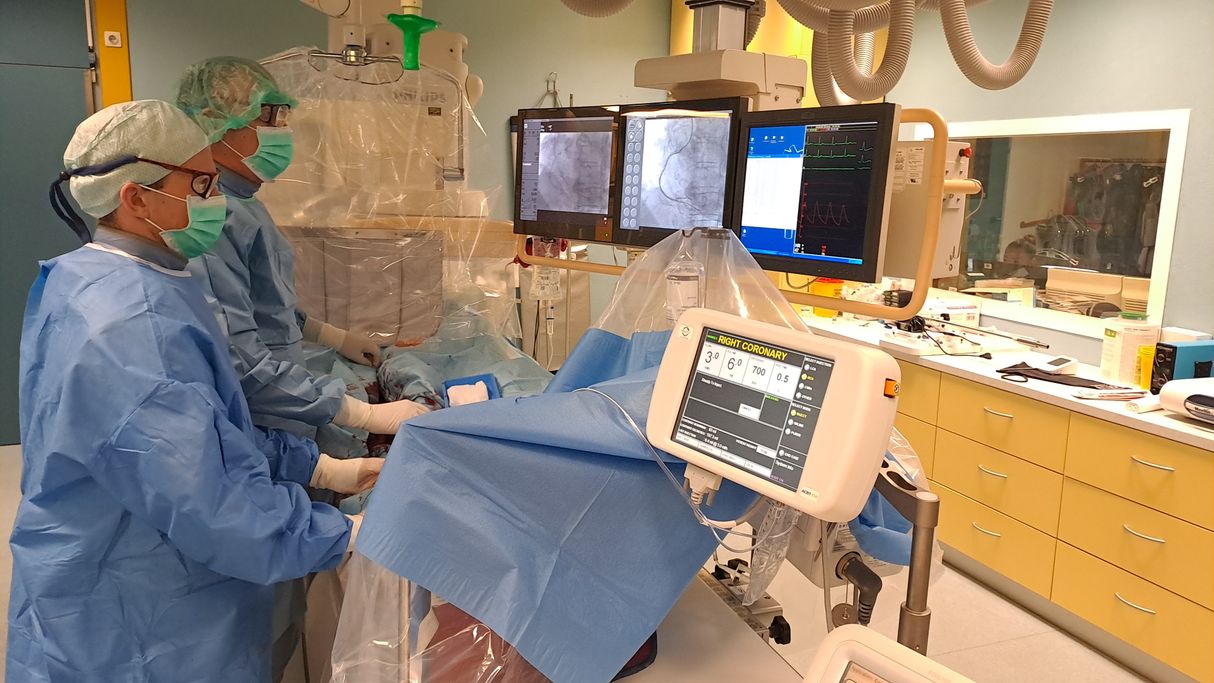 Zdravnika Dean Miletić (levo) in Matjaž Klemenc (desno) med posegom na koronarnih arterijah.